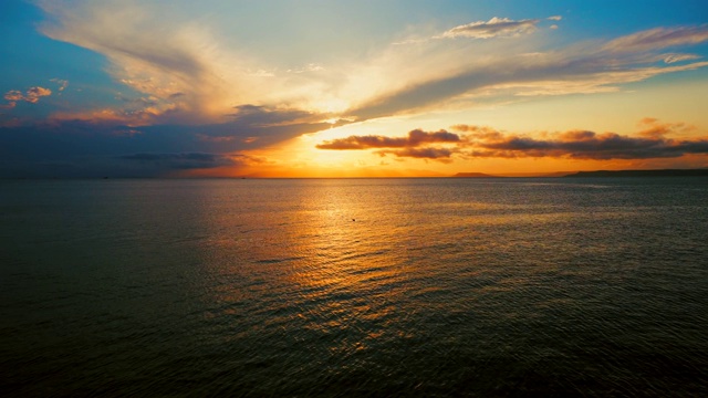 在一个愉快的夏天晚上的海景:美丽的日落，彩色的云，一个纯海与游艇，在水面上闪烁的太阳。海洋，海洋，自然视频旅游，度假和冥想的地点视频素材