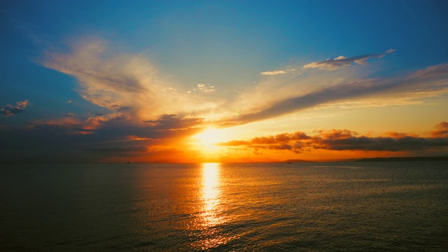 在一个愉快的夏天晚上的海景:美丽的日落，彩色的云，一个纯海与游艇，在水面上闪烁的太阳。海洋，海洋，自然视频旅游，度假和冥想的地点视频素材