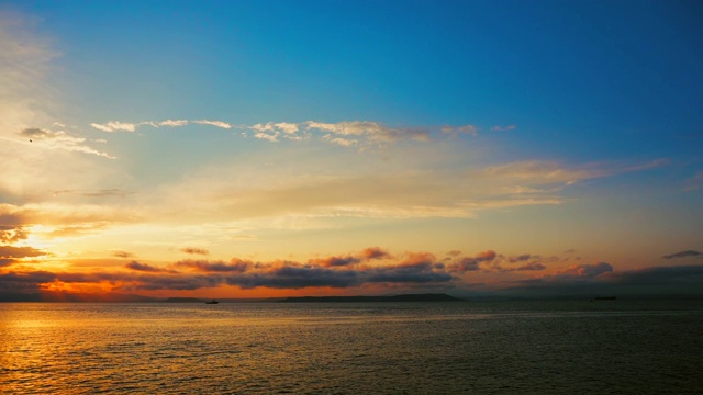 在一个愉快的夏天晚上的海景:美丽的日落，彩色的云，一个纯海与游艇，在水面上闪烁的太阳。海洋，海洋，自然视频旅游，度假和冥想的地点视频素材