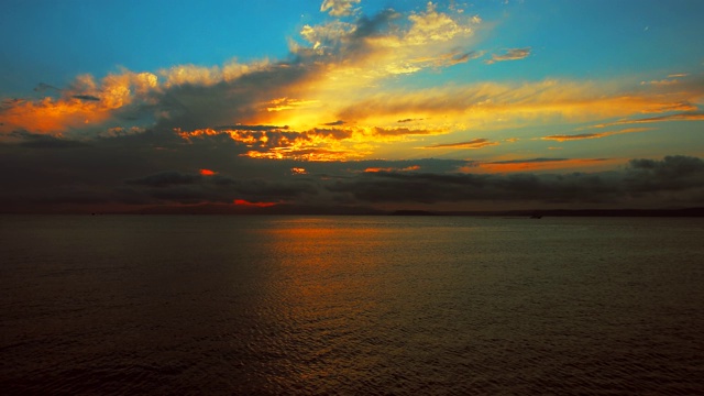 在一个愉快的夏天晚上的海景:美丽的日落，彩色的云，一个纯海与游艇，在水面上闪烁的太阳。海洋，海洋，自然视频旅游，度假和冥想的地点视频素材