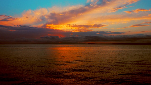 在一个愉快的夏天晚上的海景:美丽的日落，彩色的云，一个纯海与游艇，在水面上闪烁的太阳。海洋，海洋，自然视频旅游，度假和冥想的地点视频素材