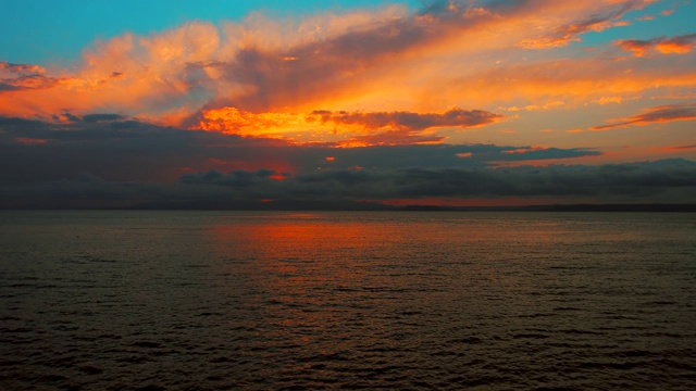 在一个愉快的夏天晚上的海景:美丽的日落，彩色的云，一个纯海与游艇，在水面上闪烁的太阳。海洋，海洋，自然视频旅游，度假和冥想的地点视频素材