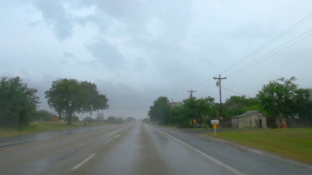 司机POV开着雨刷，行驶在德克萨斯州的一条沥青乡村公路上视频素材