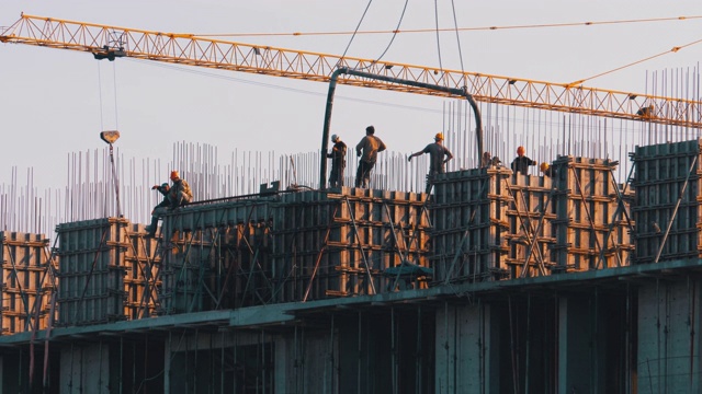 建筑施工。建筑工地上的起重机在吊起货物。建筑工地的工人视频素材