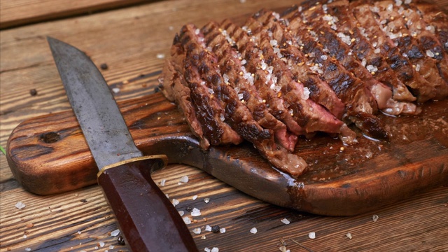 烤肉片牛肉肋眼与香料在乡村木砧板上视频素材