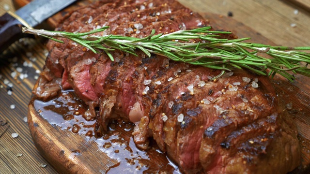 烤肉片牛肉肋眼与香料在乡村木砧板上视频素材