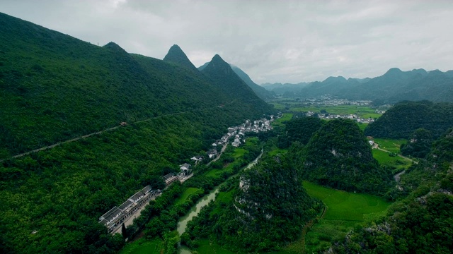 鸟瞰喀斯特山峰森林(万峰林)中的村庄和稻田，贵州，中国。视频素材