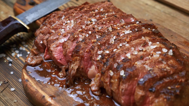 烤肉片牛肉肋眼与香料在乡村木砧板上视频素材