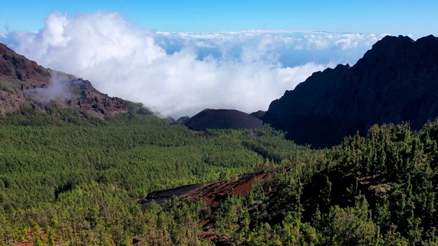 火山景观与一个火山在山谷中间被峡谷包围，松树和云从高度与无人机记录视频素材