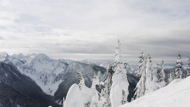 滑雪板在雪山山顶上看下滑雪坡无人机飞行过去视频素材