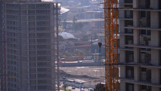 建筑工地上的塔式起重机在高层建筑中吊装重物视频素材