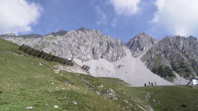 低角度全景:夏季奥地利阿尔卑斯山上的云景和电缆站，Hafelekarspitze-Seegrube在卡温德尔山，奥地利因斯布鲁克视频素材