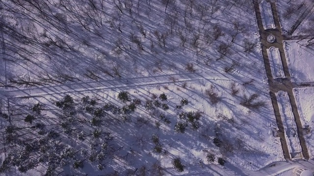 无人机飞过白雪覆盖的城市公园。雪城，自然抽象视频素材