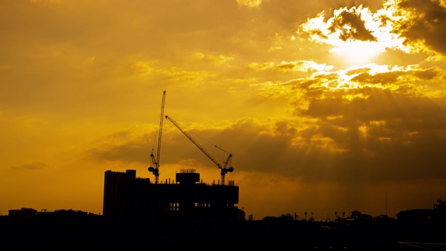 时光流逝，建筑起重机在夜晚的天空中施工视频素材