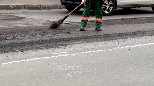 糟糕的道路。压路机和工人在铺沥青和修复城市街道。视频素材