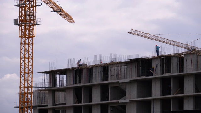 在建摩天大楼边缘的建筑商。建筑工地的工人视频素材