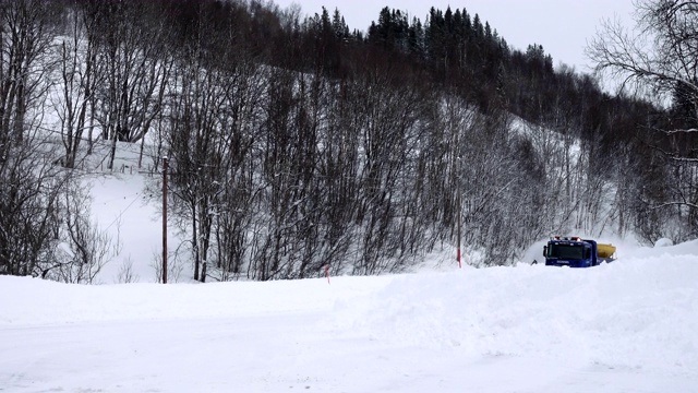 扫雪车在清理冬天被雪覆盖的道路视频素材