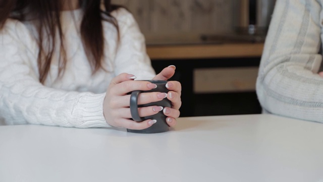 美丽的男女在厨房里饮茶，在一个现代化的室内视频素材