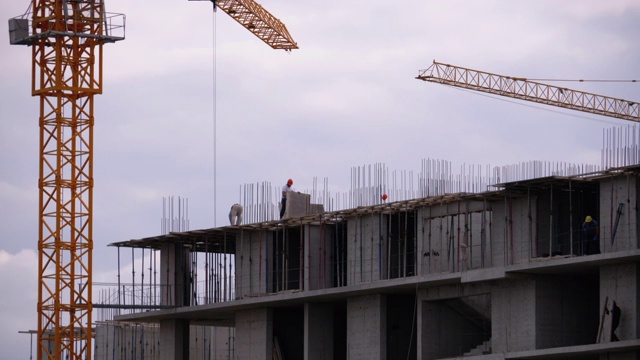 在建摩天大楼边缘的建筑商。建筑工地的工人视频素材