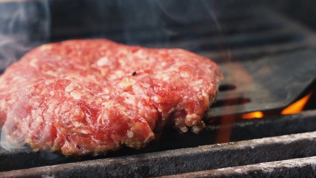 厨师清洗现成的肉，为客人准备烧烤汉堡。特写的首席烹饪美味汉堡在休闲酒吧慢动作视频素材