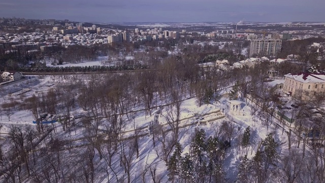 无人机飞过白雪覆盖的城市公园。雪城，自然抽象视频素材