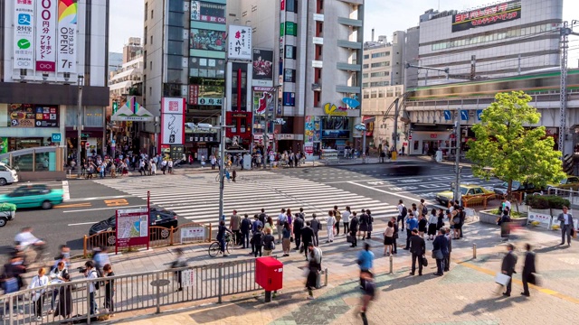 4K延时:鸟瞰东京上野美代子市场的行人拥挤的十字路口和火车行驶。视频素材