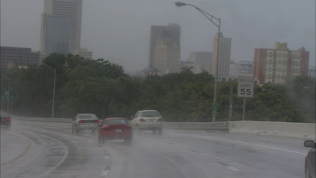 雨中交通沿着公路行驶。视频素材