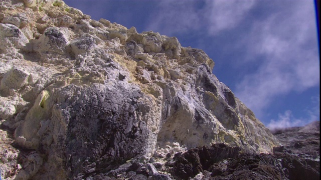 云层漂浮在火山岩上的硫磺沉积物之上。视频素材