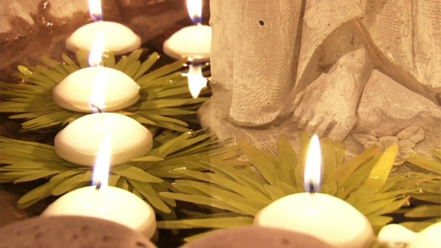 点燃的蜡烛在寺庙的水面上缓缓飘过视频素材