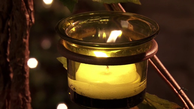 一根点燃的蜡烛在庙里的一个绿色碗里慢慢地燃烧着视频素材