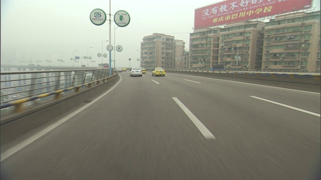 在一个烟雾弥漫的城市里，车辆在一条多车道的道路上行驶。视频素材