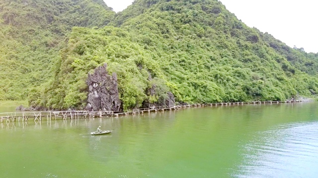 Flycam显示男子在桨船航行在海湾对岛屿视频素材