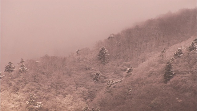 雾和雪覆盖着富士山附近的陡峭小山。视频素材