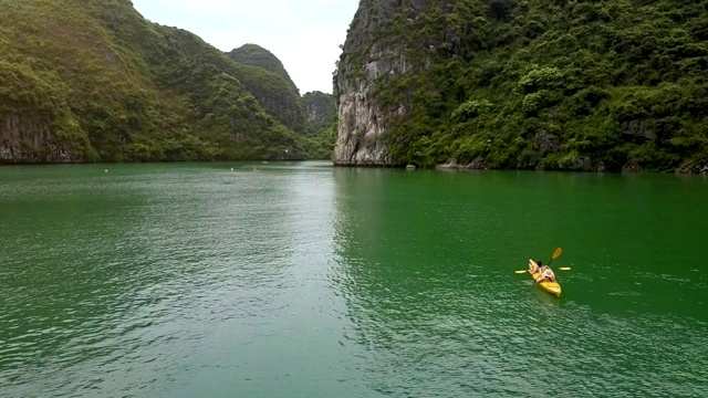 Flycam移动到宁静湾与运动员在皮划艇视频素材