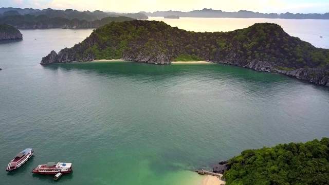 无人机移动到美丽的绿色岛屿与沙滩在海湾视频素材