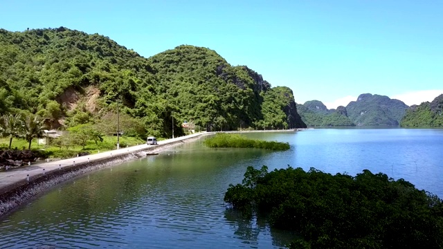 飞行摄影机显示巴士在洋湾路堤上行驶视频素材