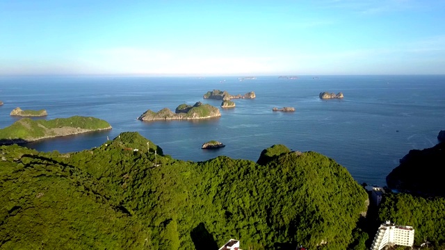 无人机从蔚蓝湾移动到岛屿，城镇对抗天空视频素材