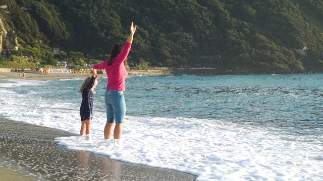 幸福的女人和女儿站在海边视频素材