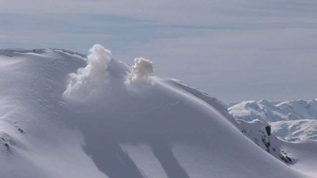 两次爆炸引发了雪山顶部附近的雪崩。视频素材