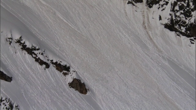 一场小雪崩从陡峭的山坡上滚下来。视频素材