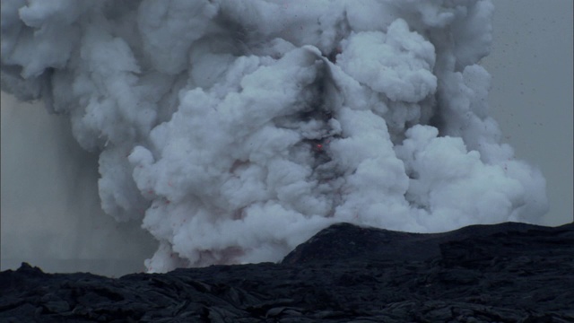 炽热的岩浆从冒纳克亚火山喷口喷出的蒸汽和火山灰中喷发出来。视频素材