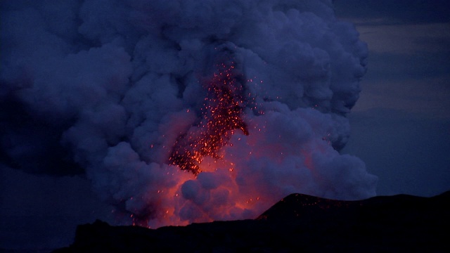 晚上，夏威夷莫纳克亚火山爆发出炽热的岩浆和巨大的蒸汽云团。视频素材