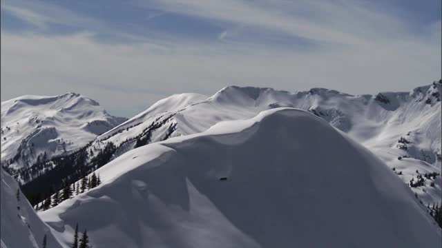 雪迅速地从山坡上滑下来，落在积雪的地面上。视频素材