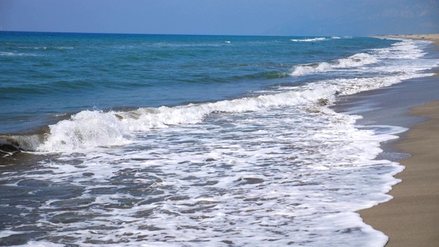 空旷的沙滩和巨大的海浪冲击着海岸线。热带度假胜地，阳光明媚的一天。风景优美的海景。慢动作视频素材