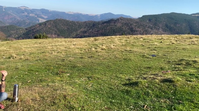 一名男子以群山为背景，摆着瑜伽姿势沉思。视频素材