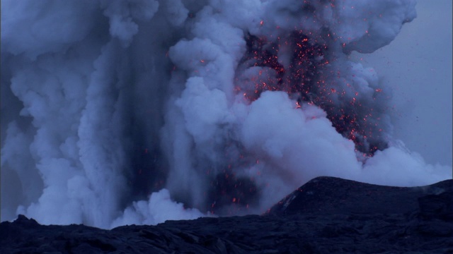 炽热的岩浆从冒纳克亚火山喷口喷出的蒸汽和火山灰中喷发出来。视频素材