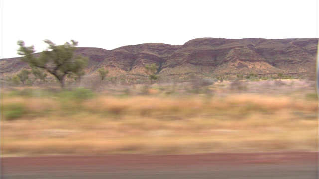 在Karijini国家公园，各种各样的树木和灌木覆盖在一个台地附近。视频素材