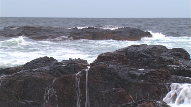 波浪冲击着多岩石的海岸。视频素材