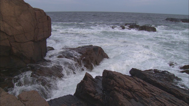 海浪冲刷着布满岩石的海岸线。视频素材