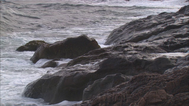 波浪冲击着多岩石的海岸。视频素材